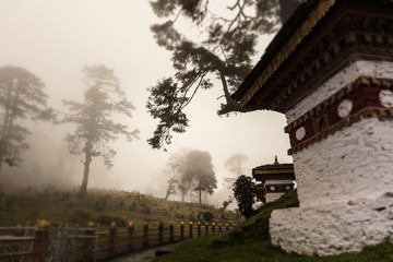 Fototapeta na wymiar Druk Wangyal, Bhutan, 108 chorten or stupas, a memorial in honor of the Bhutanese soldiers at the Dochula Pass on a cloudy foggy day in altitude of 3000 meters. A bhutanese sanctuary