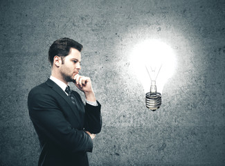 Businessman looking on glowing lamp
