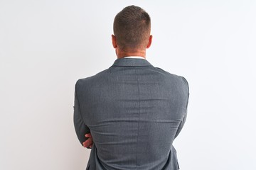 Young handsome business man wearing suit and tie over isolated background standing backwards...