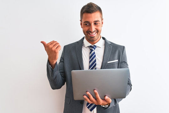 Young handsome business man working using computer laptop over isolated background pointing and showing with thumb up to the side with happy face smiling
