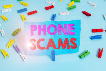 Word writing text Phone Scams. Business photo showcasing use of telecommunications for illegally acquiring money Colored clothespin papers empty reminder blue floor background office pin