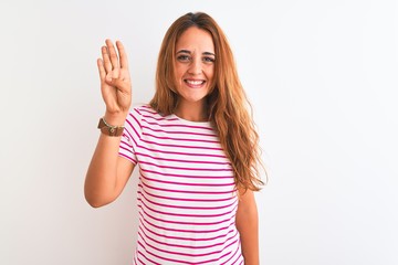 Young redhead woman wearing striped casual t-shirt stading over white isolated background showing and pointing up with fingers number four while smiling confident and happy.