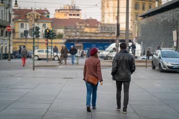 man and woman walking in Porta Palazzo market in Torino, Turin. View from the Piazza della Repubblica square. Turin, Italy