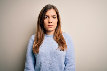 Beautiful young woman wearing casual winter sweater standing over isolated background skeptic and nervous, frowning upset because of problem. Negative person.