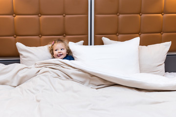petite fille joue dans un grand lit