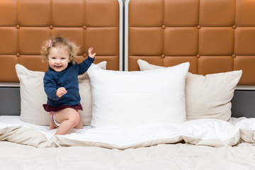 petite fille joue dans un grand lit