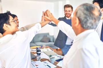 Obraz premium Group of business workers standing with hands together at the office