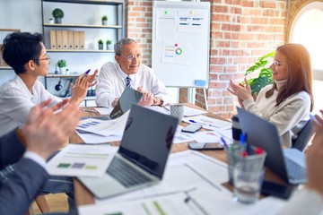 Group of business workers smiling happy and confident. Working together with smile on face applauding one of them at the office