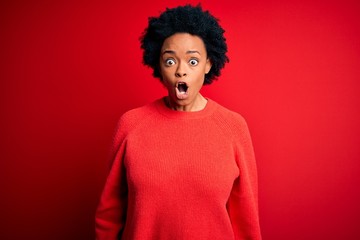 Fototapeta na wymiar Young beautiful African American afro woman with curly hair wearing casual sweater afraid and shocked with surprise expression, fear and excited face.