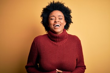 Young beautiful African American afro woman with curly hair wearing casual turtleneck sweater...