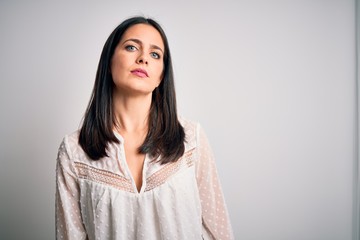 Young brunette woman with blue eyes wearing casual t-shirt over isolated white background Relaxed...