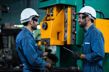 Engineer team in industry factory working setting machine with space for blue machine factory background.