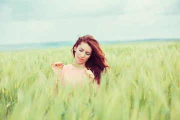 Enjoying nature. Beautiful happy woman girl outdoors on green wheat field in summer nature