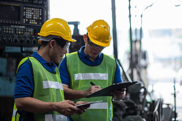 Two asian maintenance engineers discuss inspect relay checking information and protection system on...