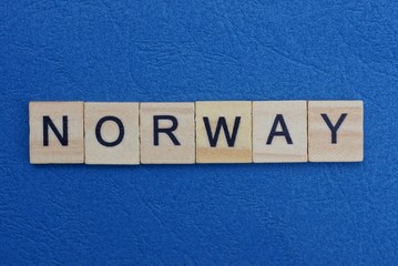 gray word norway from small wooden letters on a blue table