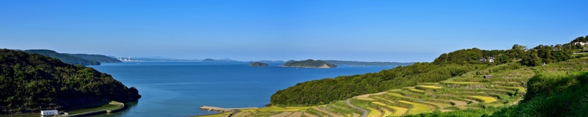 展望台から見おろす土谷棚田とコバルトブルーの海のパノラマ情景＠長崎