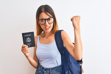 Beautiful redhead student woman wearing backpack and holding passport of united states annoyed and frustrated shouting with anger, crazy and yelling with raised hand, anger concept