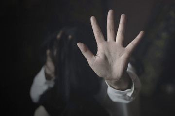 Woman covering her face in fear of domestic violence against. international women's day