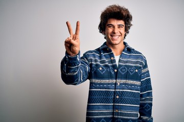 Young handsome man wearing casual shirt standing over isolated white background showing and pointing up with fingers number two while smiling confident and happy.