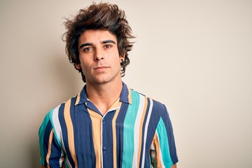 Young man on vacation wearing summer colorful shirt standing over isolated white background Relaxed with serious expression on face. Simple and natural looking at the camera.