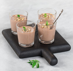 Chocolate nut jelly in a glass on a light background