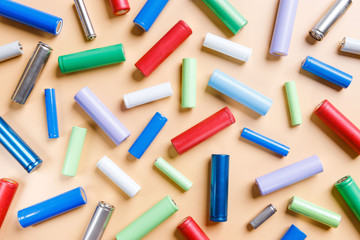 Close up of colorful used rechargeable Nickel Metal Hydride (Ni-MH) battery on beige background, flat lay. Old Nickel-Cadmium (Ni-Cd) batteries. Hazardous garbage, recycle concept 
