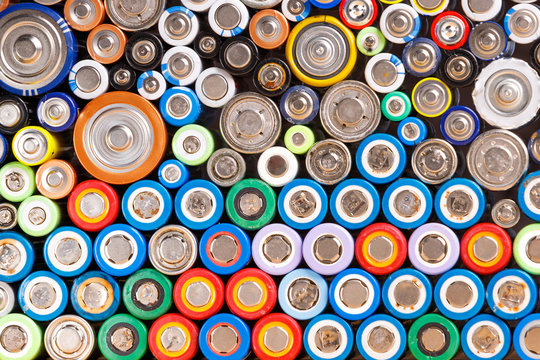 Close up of colorful spent discharged batteries of different sizes and formats. Used rechargeable Nickel Metal Hydride (Ni-MH), Nickel-Cadmium(Ni-Cd) batteries with corrosion and rust. Recycle concept