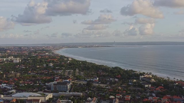 Bali Indonesia Aerial v9 Moving towards ocean high above beach clubs with city airport views - April 2019
