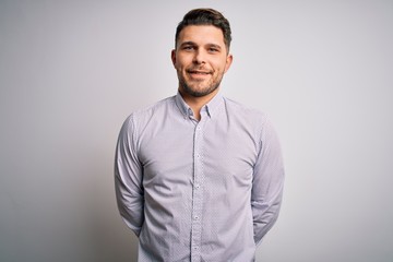 Young business man with blue eyes standing over isolated background with a happy and cool smile on face. Lucky person.