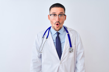 Young doctor man wearing stethoscope over isolated background afraid and shocked with surprise and amazed expression, fear and excited face.