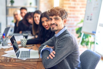 Fototapeta premium Group of business workers sitting in line with smile on face. Looking at the camera, young man smiling at the office