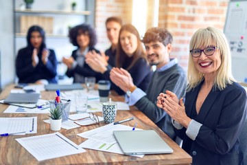 Group of business workers smiling happy and confident. Working together with smile on face looking at the camera applauding at the office