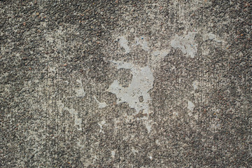 灰色でザラザラした中に滑らかな部分があるコンクリート舗装の表面