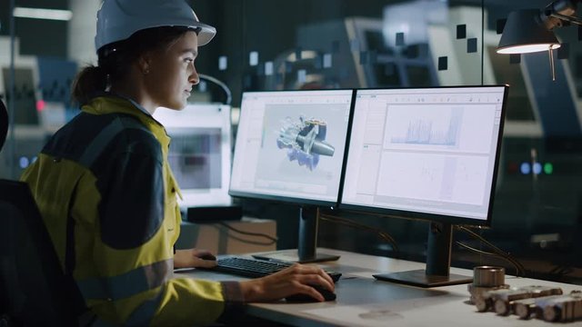 Young and Confident Industrial Engineer Working on Computer, on Screen CAD Software Showing Eco-Friendly New Electric Engine Prototype. Industrial Factory with High-Tech CNC Machinery