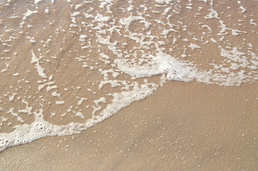 Ocean wave on sandy beach, background