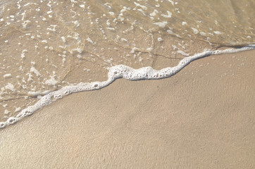 Fototapeta na wymiar Ocean wave on sandy beach, background