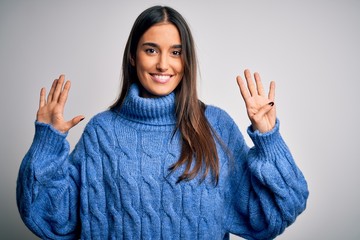 Young beautiful brunette woman wearing casual turtleneck sweater over white background showing and...