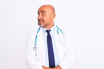 Middle age doctor man wearing stethoscope and tie standing over isolated white background smiling looking to the side and staring away thinking.