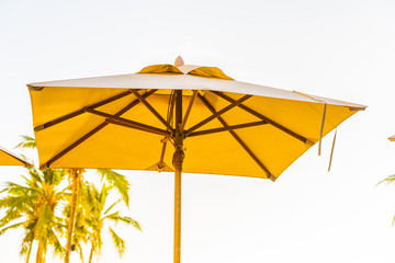 Obraz na płótnie Canvas Beautiful tropical nature umbrella chair with palm tree around beach sea ocean at sunset or sunrise