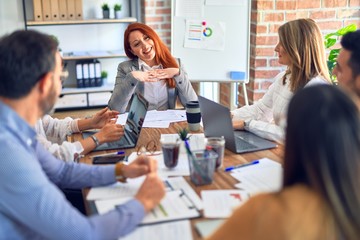 Group of business workers working together. Sitting on desk using laptop reading documents at the office