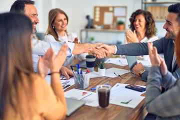 Group of business workers smiling happy and confident. Working together with smile on face shaking hands at the office