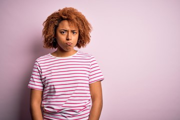 Young beautiful African American afro woman with curly hair wearing casual striped t-shirt depressed and worry for distress, crying angry and afraid. Sad expression.