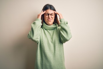 Young beautiful woman wearing casual sweater standing over isolated white background with hand on head for pain in head because stress. Suffering migraine.