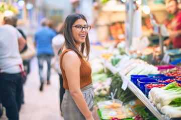 Young beautiful woman smiling happy and confident. Standing with smile on face buying food at supermarket
