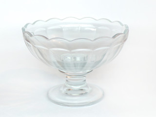 Vase and bowl made of glass on a white background. Crystal kitchen utensils isolated on white background. Cup for desserts.