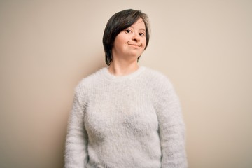 Young down syndrome woman standing over isolated background smiling looking to the side and staring away thinking.