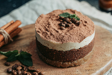 Tiramisu on a beige plate. Coffee with cinnamon. Raw dessert	