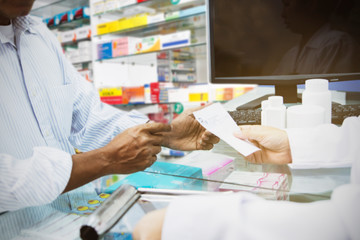 Blur image  senior sick man stood to buy medicines from the female pharmacist in the pharmacy to cure the illness : Blurred background