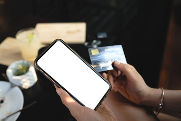 Young woman  shopping online with credit card using smart blank phone at home Indoor.