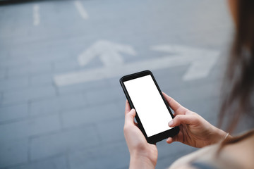 Closeup of male hand holding and using modern smart phone with blank screen for your text or content, with city bokeh